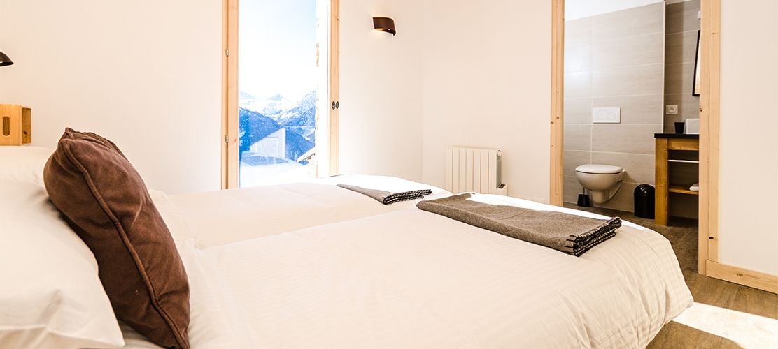 An ensuite chalet bedroom with mountain views